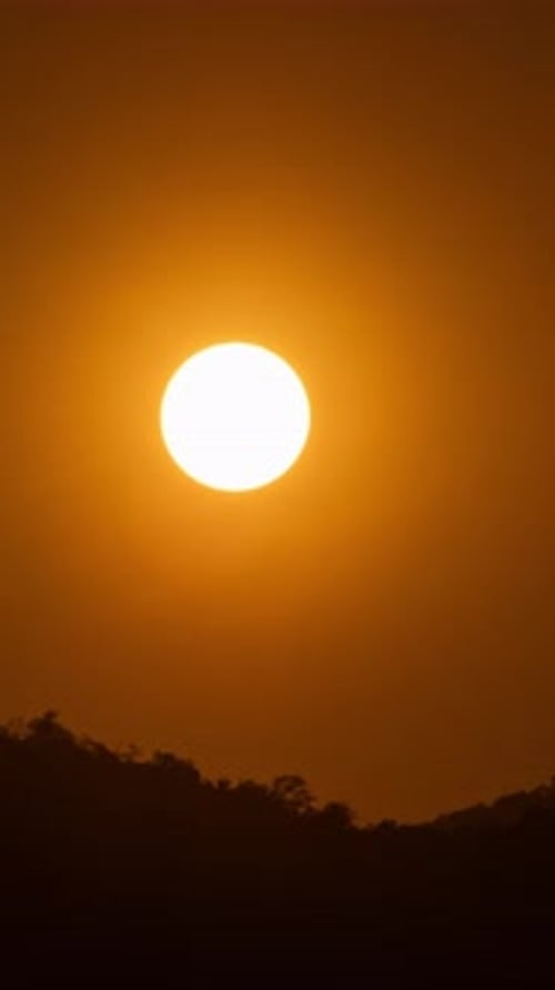 Timelapse of dramatic sunset with orange sky in a sunny day.