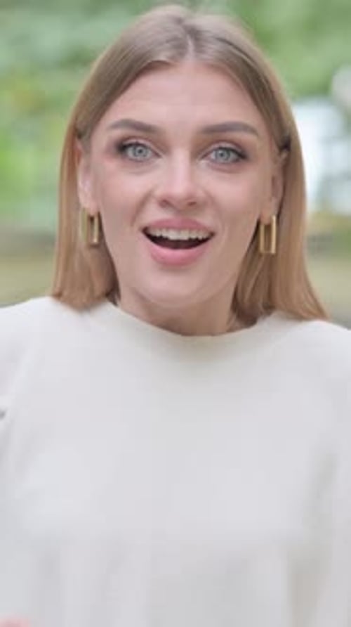 Excited Woman Smiles with Celebration Gesture in Park