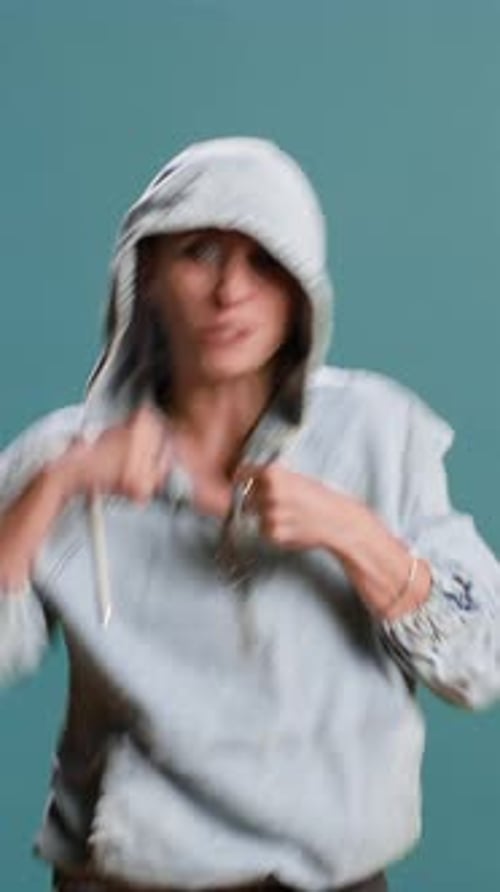 Vertical Video Strong Bold Woman Flexing Muscles and Throwing Punches in Studio