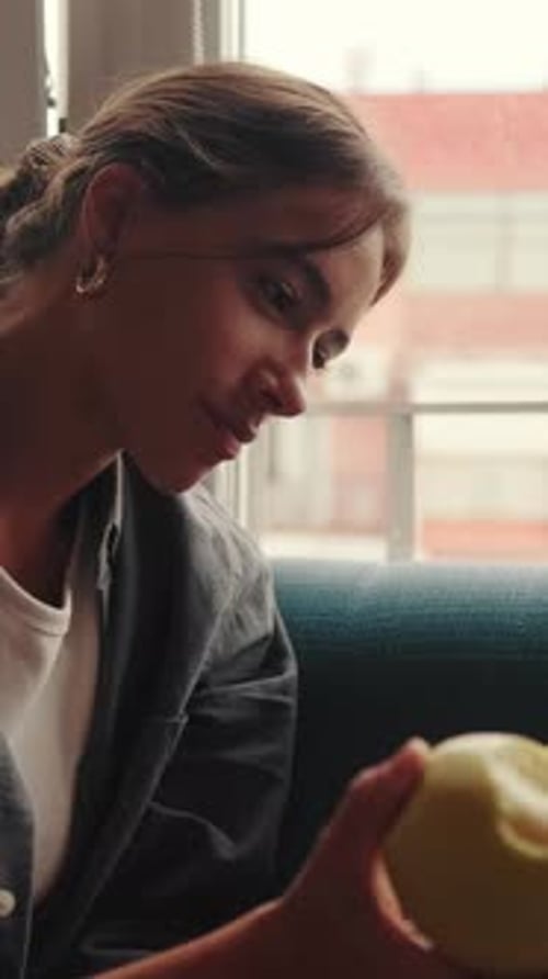 Young Woman Eating an Apple Indoors