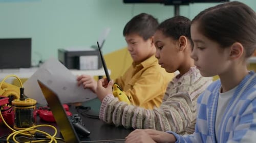 Multiethnic Elementary Students Building Robots in Modern Classroom