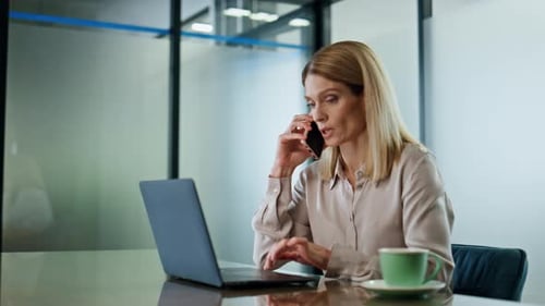 Confident Businesswoman Talking on Cellphone in Office