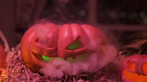 Close up, cool smoking carved pumpkin traditional jack o lantern decorating house doorstep