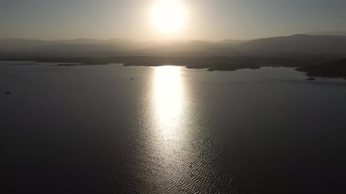 Aerial drone flying over a lake, water dam, with mountains at sunrise. Beautifull dreamy landscape v