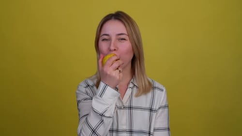 Close up portrait of girl biting and eating tasty red apple. Hungry woman with appetite biting juicy