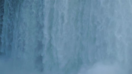 Tracking tilt down close-up of waterfall into mist Niagara falls slow motion