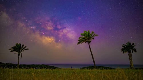 Milky way and shooting stars streaking the sky in the coast. Time lapse