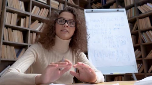 Young Woman Hispanic School Math Teacher, Coach or Tutor Wearing Glasses Looking