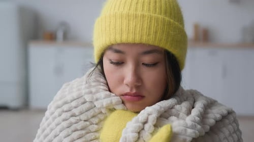 Triste bouleversée, asiatique, chinoise, japonaise, coréenne, dans un appartement froid, problème de chauffage