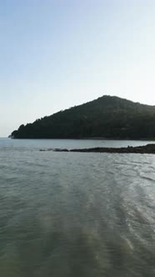 Vertical Video Aerial View of a Tropical Beach with Golden Sand and Blue Sea Waves