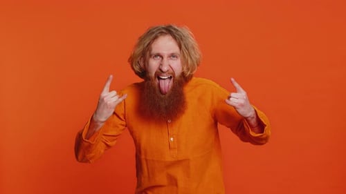 Glücklicher, fröhlicher Mann, der Rock 'n' Roll-Geste mit den Händen zeigt, cooles Schild, verrückter Ausdruck, tanzt, gewinnt den Sieg