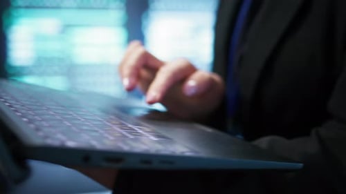 Programador no hub do servidor verificando o plano de recuperação no laptop de perto