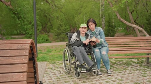 Springtime Park Scene With Woman And Young Man Engaging With Book Woman And Young Man Sharing Joyful
