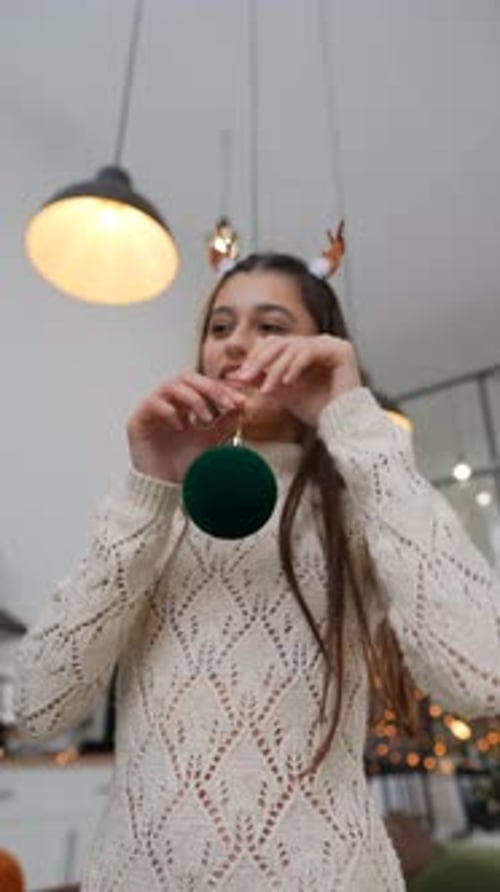 A Young Woman Holding a Beautiful Ornament in a Cozy and Inviting Interior Space