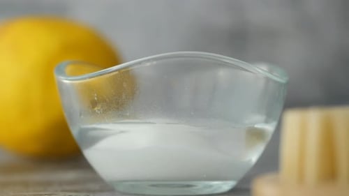 Pouring Baking Soda Powder in a Bowl of Water