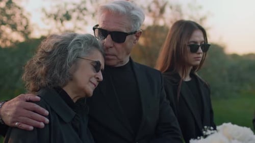Mourning Family at Cemetery during Sunset