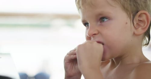 Young Child Eating Nugget in Bright Setting