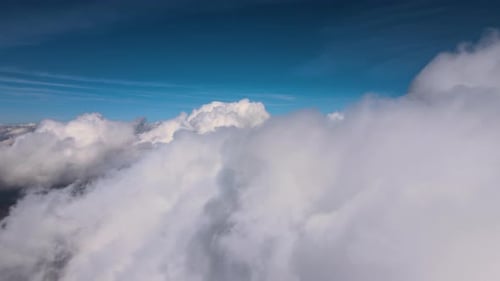 Aerial View From Airplane Window at High Altitude of Earth Covered with Puffy Cumulus Clouds Forming