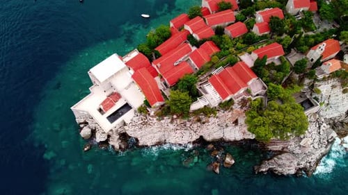 Aerial view of Sveti Stefan island and shore in a beautiful summer day, Montenegro from flying drone