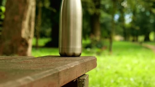 Water Bottle Reusable Steel Thermo Water Bottle on Wooden Bench Isometric Concept Sustainable