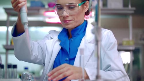 Woman Scientist Using Pipette in Laboratory