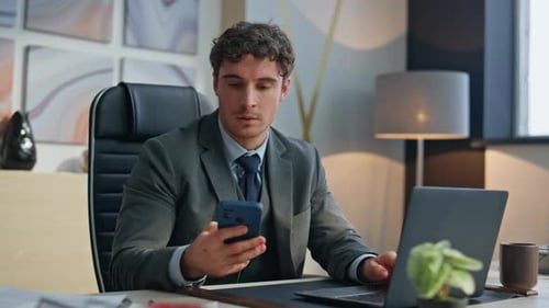 Young Adult Working at Desk Talking on Phone