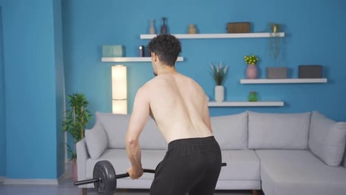 Muscular Man Lifting Weights at Home