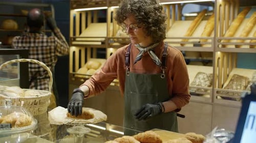 Female Worker Preparing Fresh Croissants for Sale in Bakery