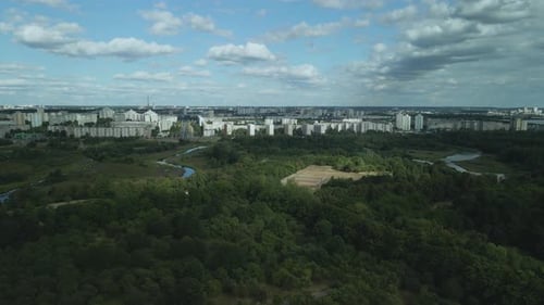 City with high-rise buildings. Park area in the foreground. Blue sky with clouds. Aerial photography