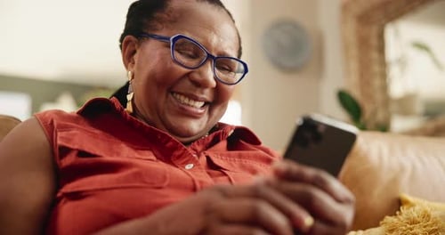 Smiling Senior Woman Using Smartphone at Home