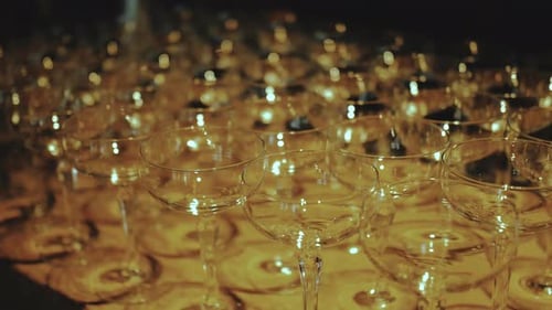 Dolly Shot of Many Empty Wine Glasses Kept on Table the Warm Light of the Lamps Falls on the Glasses