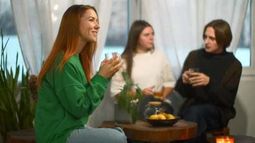Students Talk and Relax in Cozy Cafe Media Beautiful Young Woman is Drinking Tea on Background of
