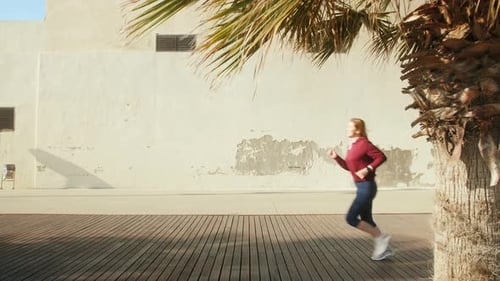 Woman Jogging on Boardwalk in City