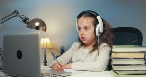 Focused Girl Learns Online, Takes Notes