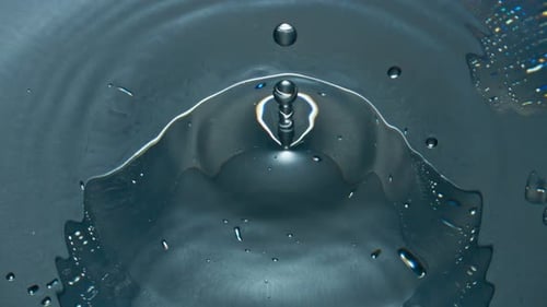 Water Drop Creates Ripples on Gray Surface