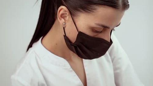 Cosmetologist Wearing Black Protective Mask in Wellness Studio Skin Care Professional Performing