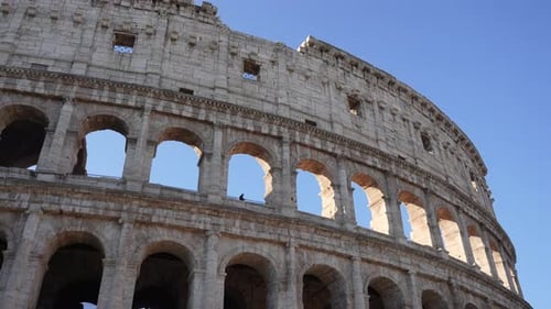 Tracking Shot of Roman Colosseum Amphitheater on Sunny Day on Background of Clear Blue Sky In