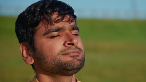 Young Indian Man Breathing Fresh Air in a Field
