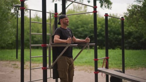Man Doing Leg Raises Exercise at Outdoor Gym