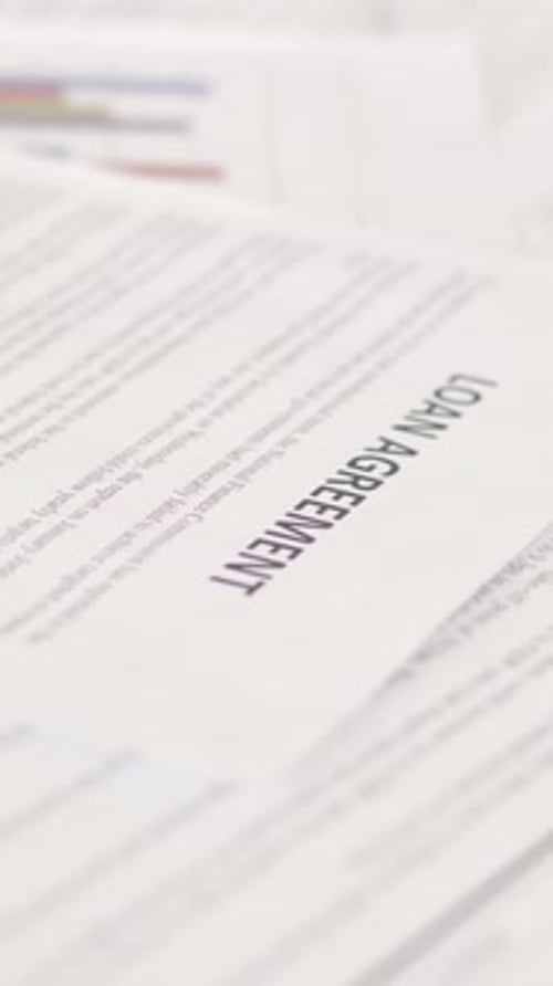 Vertical Close-Up of Loan Agreement Document in Office