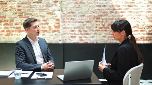Business Meeting Professional Man and Woman Discussing Contract Details in Office