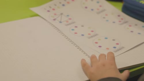 Child Completes Math Worksheet at School