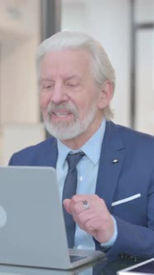 Senior Man Attending Virtual Meeting on Laptop
