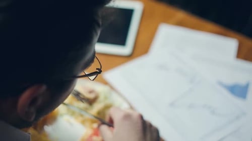 Person Eating Lunch While Working at Table
