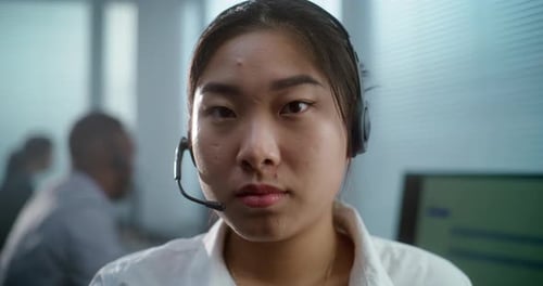 Close Up Portrait of Asian Woman in Headset Working in Call Center Office