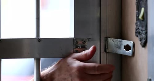 Person leaving home closing metal iron gate entrance
