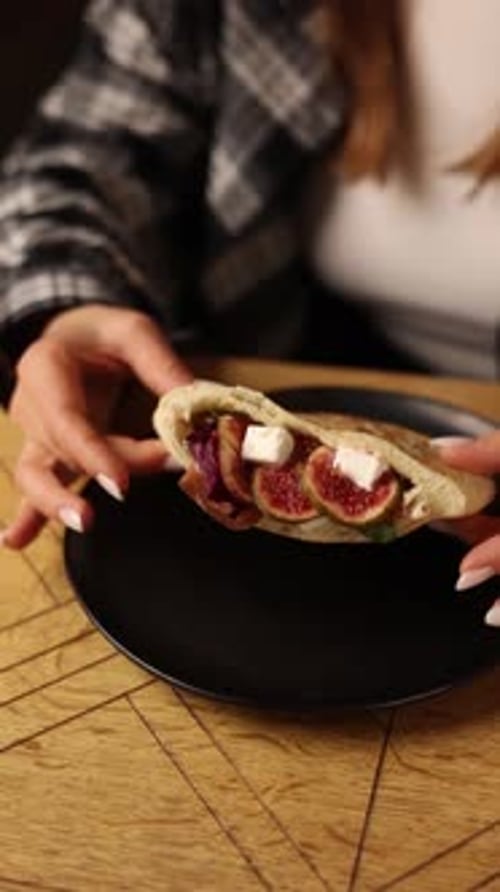 pitas with different fillings on a black plate in a restaurant