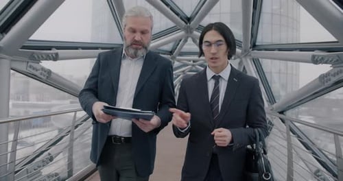 Businessmen Discussing Plans While Walking Indoors