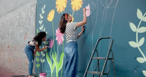 Women, students and painting mural on wall of creative decoration, community project