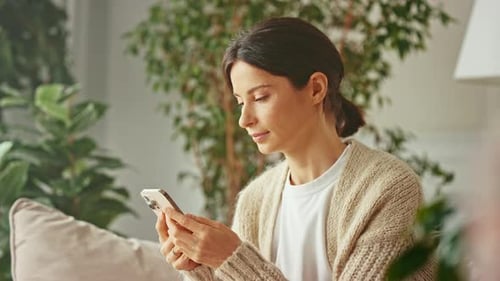 Woman Using Smartphone Device in Home Setting